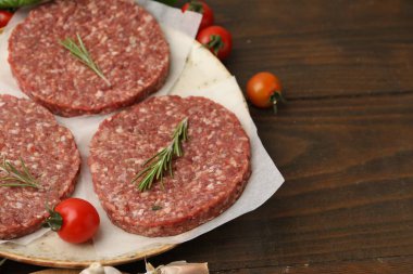 Biberiyeli pişmemiş köfte ve ahşap masada domatesler, yakın plan. Metin için boşluk