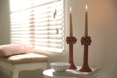 Beyaz masa üzerinde yanan mumlar olan zarif şamdanlar, metin için yer.