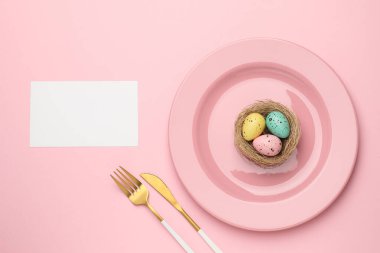 Paskalya kutlaması. Renkli yumurtalar ve pembe arka planda boş bir kart ile şölen masası ayarı, metin için boşluk ile düz yatıyordu