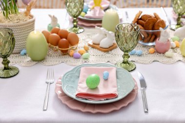 Paskalya kutlaması. Çiçek desenli ve kapalı mekanda yumurta boyalı şenlik masası.