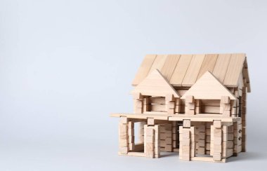 Hafif arka planda tahta bloklardan yapılmış bir ev. Metin için boşluk