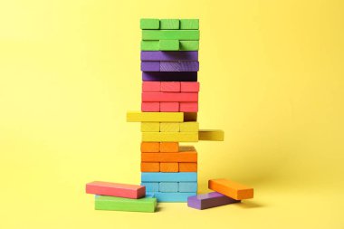 Sarı arkaplanda renkli bloklar kulesi