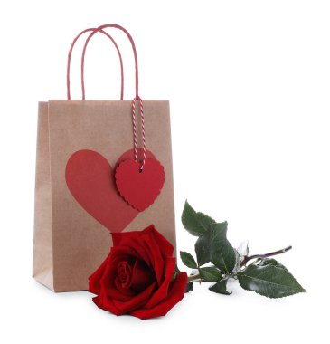 Kalbi olan bir hediye çantası ve bembeyaz bir gül. Sevgililer Günü