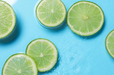 Açık mavi zemin üzerinde limon dilimleri, düz uzanmış.