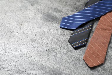 Gri masada şık çizgili kravatlar, yakın plan. Metin için boşluk