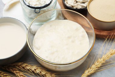 Çiğ hamur, malzemeler ve çiviler gri masada, yakın plan.