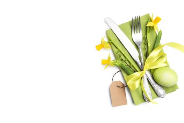 Paskalya sofrası. Güzel gümüş çatal bıçak, çiçek dekoru ve beyaz renkte izole edilmiş yumurta.