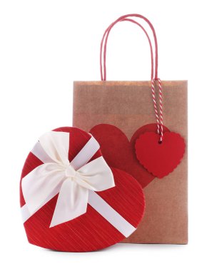 İçinde kalp şeklinde hediye paketi olan kağıt torba beyaza izole edilmiş. Sevgililer Günü