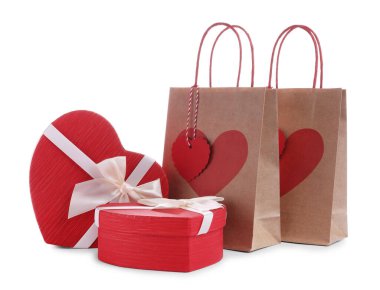 İçinde kalp şeklinde hediye paketleri olan kağıt torbalar beyaza izole edilmiş. Sevgililer Günü