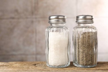 Ahşap masada tuzluk ve biberlik, yakın plan. Metin için boşluk