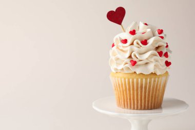 Sevgililer Günün kutlu olsun. Açık gri arka planda üzerinde kalp şeklinde süslemeler ve süslemeler olan lezzetli kek, yakın plan. Metin için boşluk