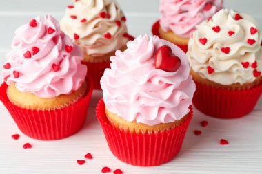 Sevgililer Günün kutlu olsun. Beyaz ahşap masada kalp şeklinde serpiştirilmiş lezzetli kek, yakın plan.