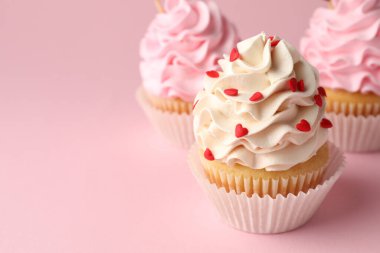 Sevgililer Günün kutlu olsun. Pembe arka planda kırmızı kalpleri olan lezzetli kekler, yakın plan. Metin için boşluk