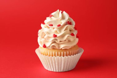 Sevgililer Günün kutlu olsun. Kırmızı arka planda kalpleri olan lezzetli kek, yakın plan.