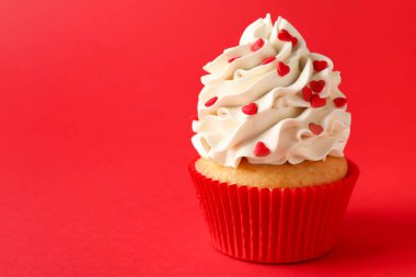 Sevgililer Günün kutlu olsun. Kırmızı arka planda kalpleri olan lezzetli bir kek, yakın plan. Metin için boşluk