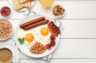 Geleneksel İngiliz kahvaltısı. Lezzetli, güneşli, domuz pastırmalı yumurtalar ve beyaz ahşap masada servis edilen sosisler, düz yatak. Metin için boşluk