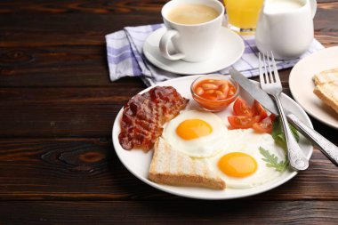 Geleneksel İngiliz kahvaltısı ahşap masada servis edilir. Metin için boşluk