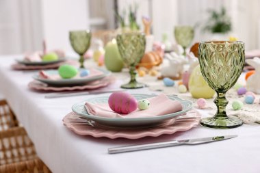 Paskalya kutlaması. Kapalı mekanda boyanmış yumurtalarla şenlik masası, yakın plan.
