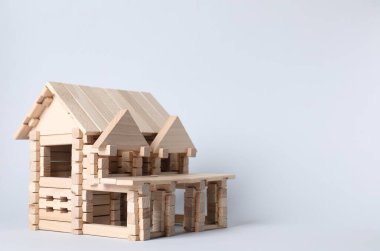 Hafif arka planda tahta bloklardan yapılmış bir ev. Metin için boşluk