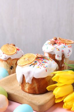 Lezzetli Paskalya pastaları, laleler ve masanın üzerine boyanmış yumurtalar. Arka planda, yakın plan. Metin için boşluk