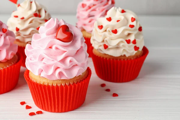 Sevgililer Günün kutlu olsun. Beyaz ahşap masada kalp şeklinde serpiştirilmiş lezzetli kek, yakın plan.