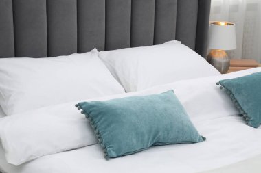 Yatak odasında temiz çarşafları olan rahat bir yatak, yakın plan.