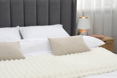 Yatak odasında temiz çarşafları olan rahat bir yatak, yakın plan.