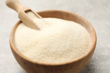 Jelatin tozu ve kepçeler açık gri masada, yakın plan.