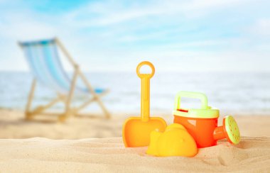 Deniz kenarındaki kumda parlak plastik plaj oyuncakları, pankart tasarımı. Yaz zamanı.