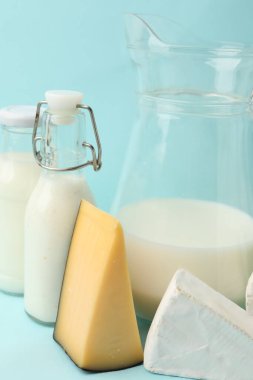 Açık mavi arka planda farklı süt ürünleri, yakın plan