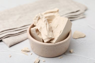 Beyaz masadaki kasede taze maya parçaları, yakın plan.