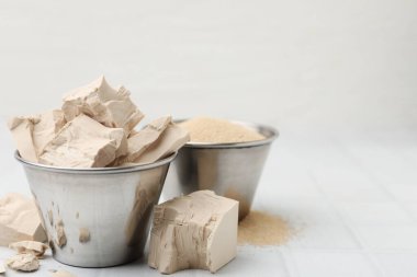 Beyaz fayanslı masada taze ve kuru maya, yakın plan. Metin için boşluk