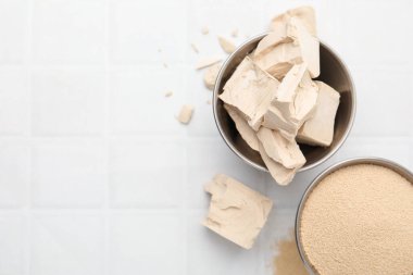 Beyaz fayanslı masada taze ve kuru maya, düz. Metin için boşluk