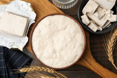 Fresh yeast dough and ingredients on wooden table, flat lay