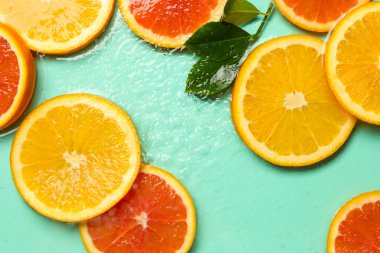 Turkuaz arka planda turkuaz meyveler ve yeşil yapraklar.