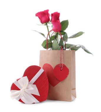 Kalp şeklinde hediye paketi ve beyaz üzerine izole güller. Sevgililer Günü