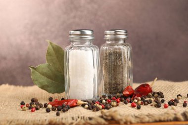 Çuval bezinde baharat olan tuzluk ve biberlikler bulanık arka planda, yakın plan