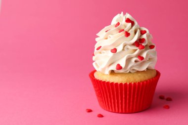 Sevgililer Günün kutlu olsun. Pembe arka planda kırmızı kalpleri olan lezzetli kek, yakın plan. Metin için boşluk