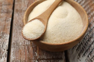 Jelatin tozu ve kaşık kasede ahşap masada, yakın plan.