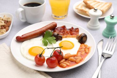 Geleneksel İngiliz kahvaltısı açık gri masada servis edilir, yakın plan.