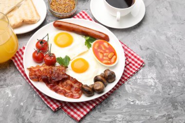 Geleneksel İngiliz kahvaltısı desenli gri masada servis edilir, yakın plan.