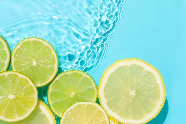 Açık mavi arka planda limon ve limon dilimleri, düz. Metin için boşluk
