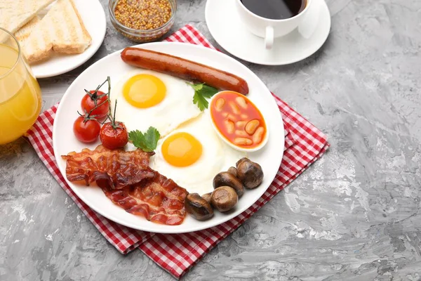 Geleneksel İngiliz kahvaltısı desenli gri masada servis edilir, yakın plan.