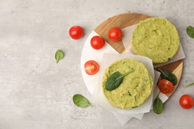 Pişmemiş nohut köfteleri, ıspanaklı ve domatesli gri desenli masa, düz yatak. Metin için boşluk