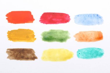 Beyaz kağıt üzerinde boyalı suluboya vuruşlar, üst görünüm