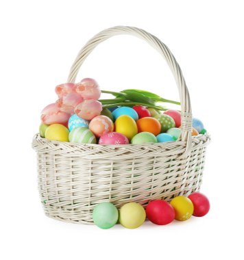 Boyanmış Paskalya yumurtaları ve hasır sepetin içindeki güzel laleler beyaza izole edilmiş.