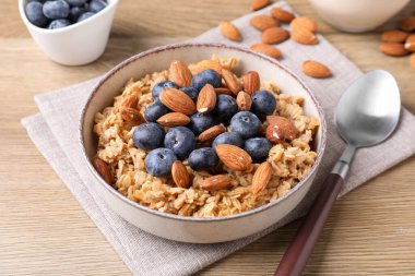 Bademli yulaf ezmesi ve ahşap masada yaban mersini, yakın plan.