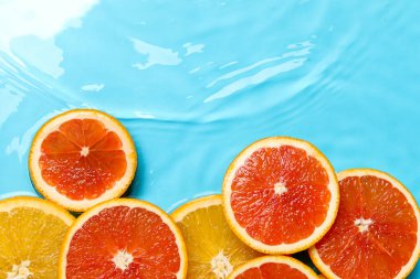 Açık mavi zemin üzerinde su içinde narenciye dilimleri, düz yatıyordu. Metin için boşluk
