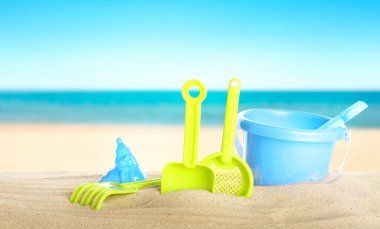 Deniz kenarındaki kumda parlak plastik plaj oyuncakları, pankart tasarımı. Yaz zamanı.