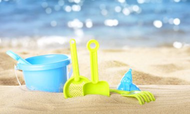 Deniz kenarındaki kumda parlak plastik plaj oyuncakları, pankart tasarımı. Yaz zamanı.